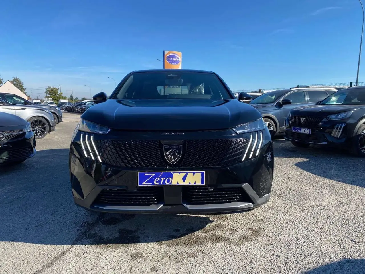 Vue avant d'un Peugeot 3008 noir 2025 avec calandre noire et feux LED à griffes distinctifs, sur un parking en extérieur.