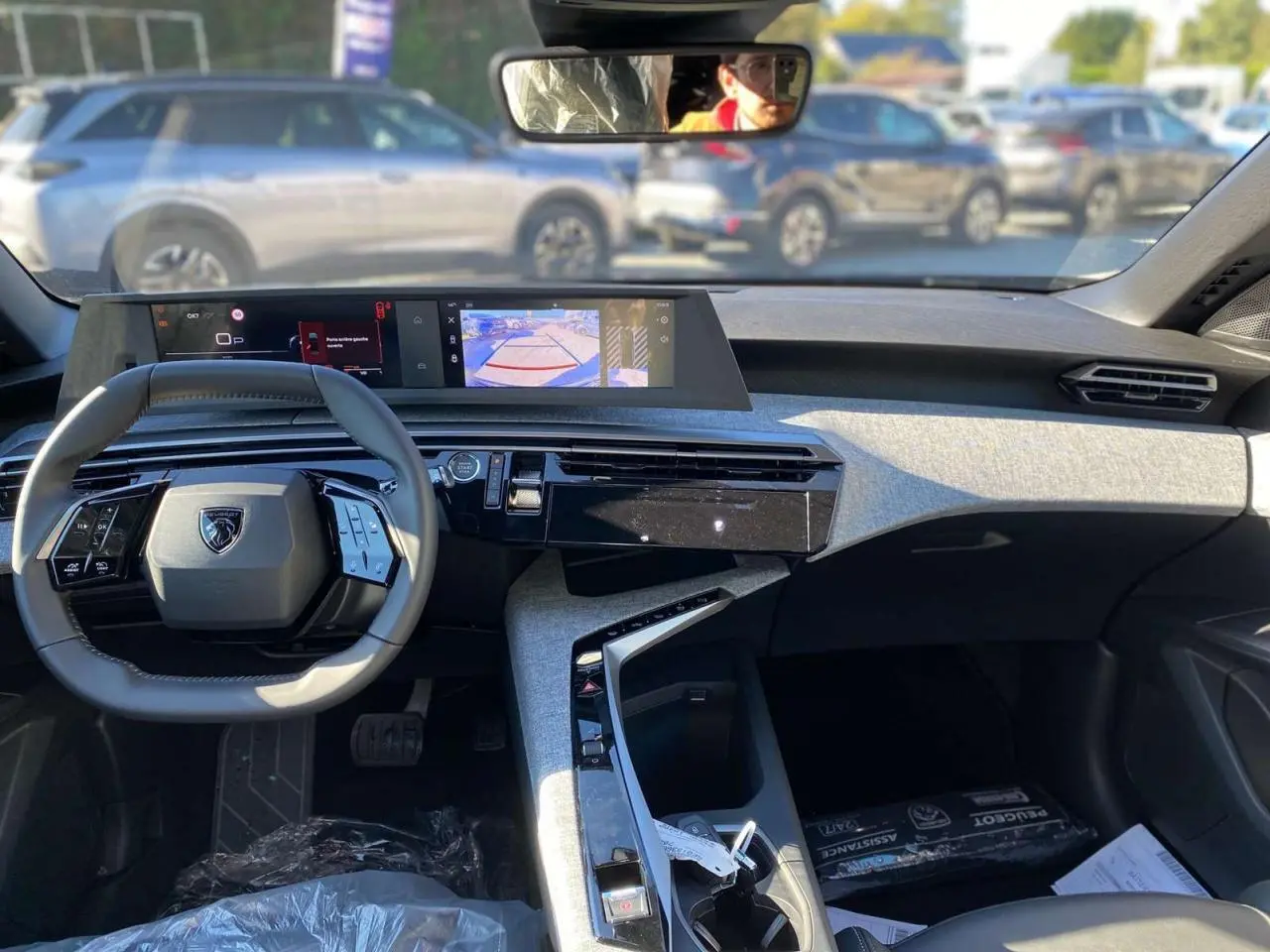 Vue intérieure avant du tableau de bord et volant gris du Peugeot 3008 noir 2025 avec écran tactile et console moderne.