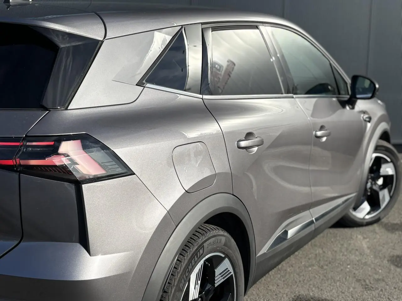 Vue 3/4 arrière droite du Renault Symbioz gris Cassiopée avec jantes 18 pouces et hayon mains libres visible.