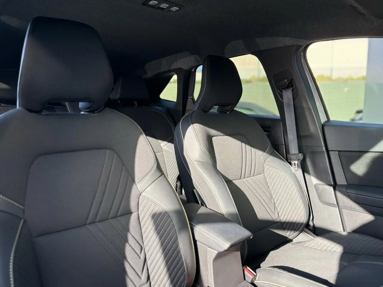 Vue intérieure des sièges avant en tissu gris avec coutures contrastantes du Renault SYMBIOZ E-Tech Full Hybrid 2025.