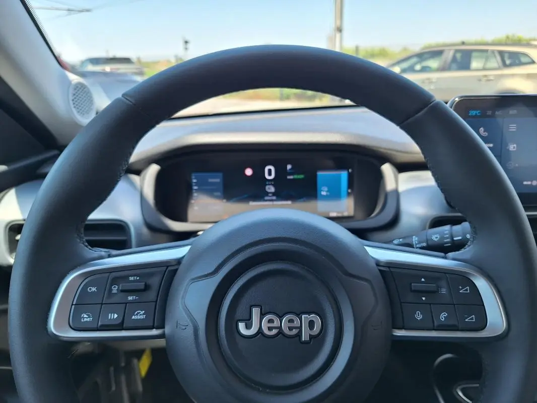 Vue rapprochée du volant Jeep Avenger électrique 2025, avec commandes intégrées et tableau de bord numérique visible.