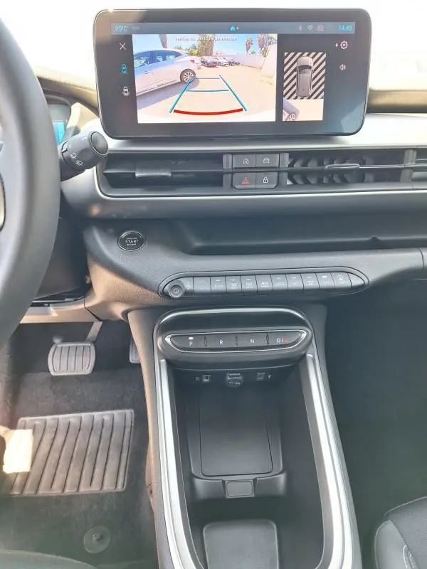 Vue intérieure du tableau de bord du Jeep Avenger électrique blanc, avec écran tactile affichant la caméra de recul.