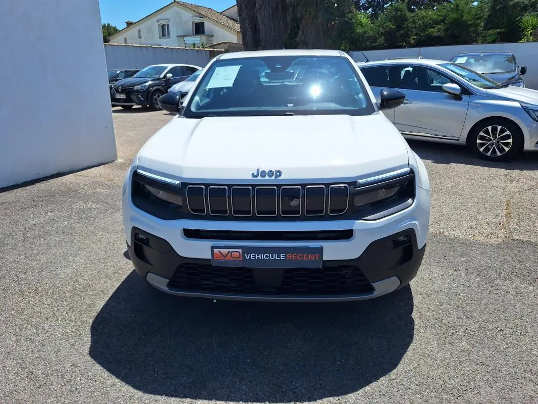 Vue avant d'un Jeep Avenger électrique blanc 2025 avec calandre noire et phares LED distinctifs.