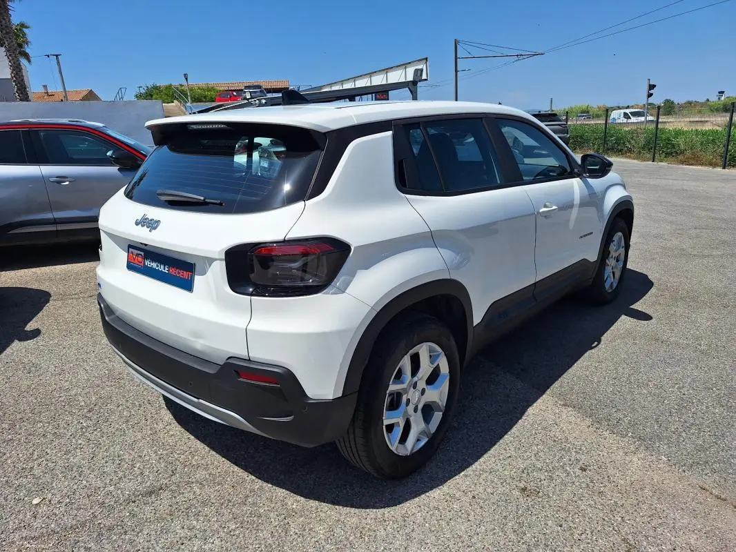Jeep Avenger électrique blanc vu en 3/4 arrière droit, avec jantes alliage 17 pouces et feux arrière noirs.