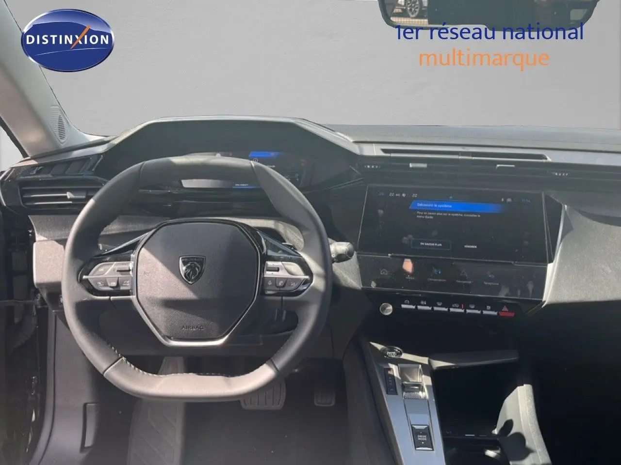 Vue intérieure centrée sur le volant et le tableau de bord de la Peugeot 308 Hybrid 145ch noir métal, écran tactile visible.
