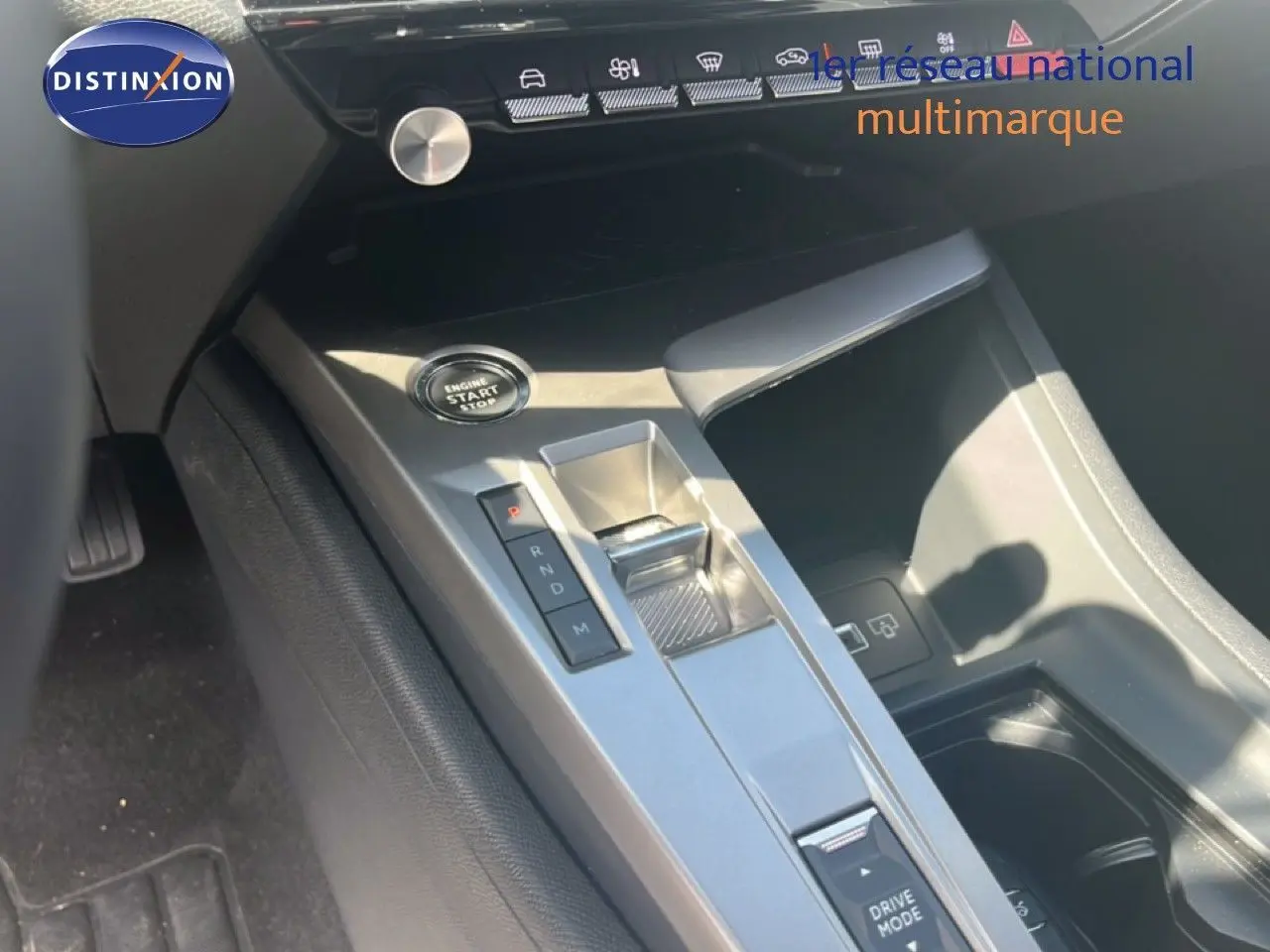 Gros plan sur la console centrale grise avec bouton start/stop et levier de boîte automatique dans une Peugeot 308 noir métal 2025.