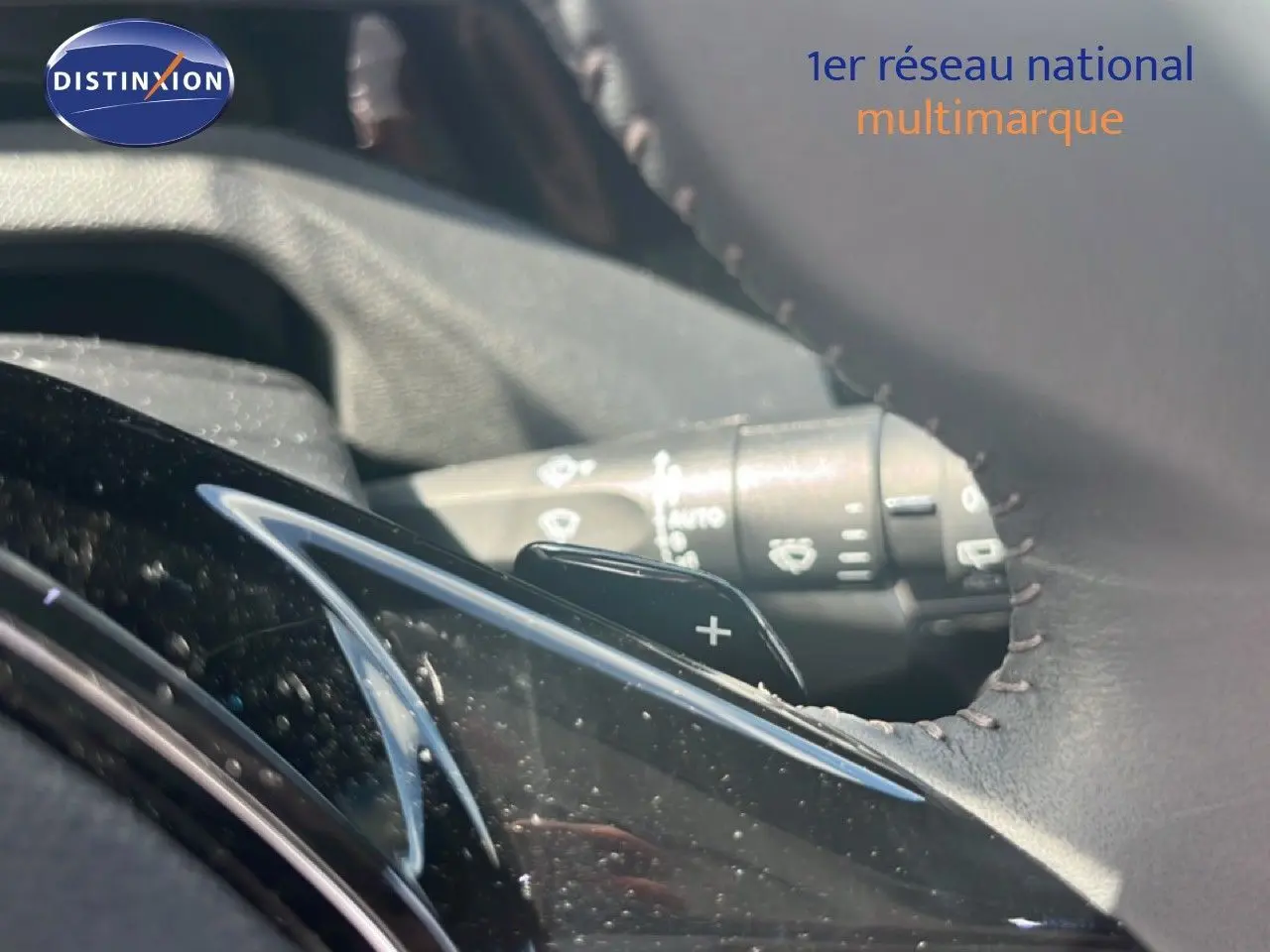 Gros plan sur la palette de changement de vitesse côté droit du volant en cuir noir d’une Peugeot 308 Hybrid 2025 noir métal.