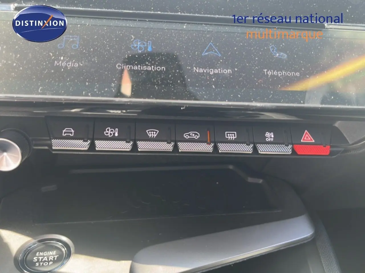 Vue rapprochée du tableau de bord de la Peugeot 308 Hybrid 2025, avec commandes tactiles et bouton start/stop visible.