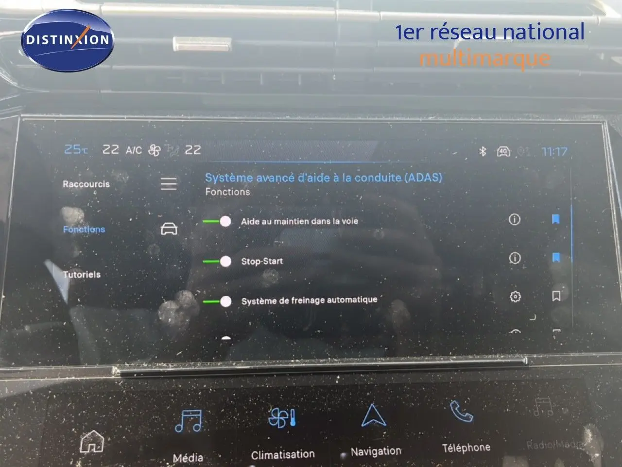 Écran tactile intérieur de la Peugeot 308 Hybrid 145ch Allure 2025, affichant les aides à la conduite, avec reflets et traces.