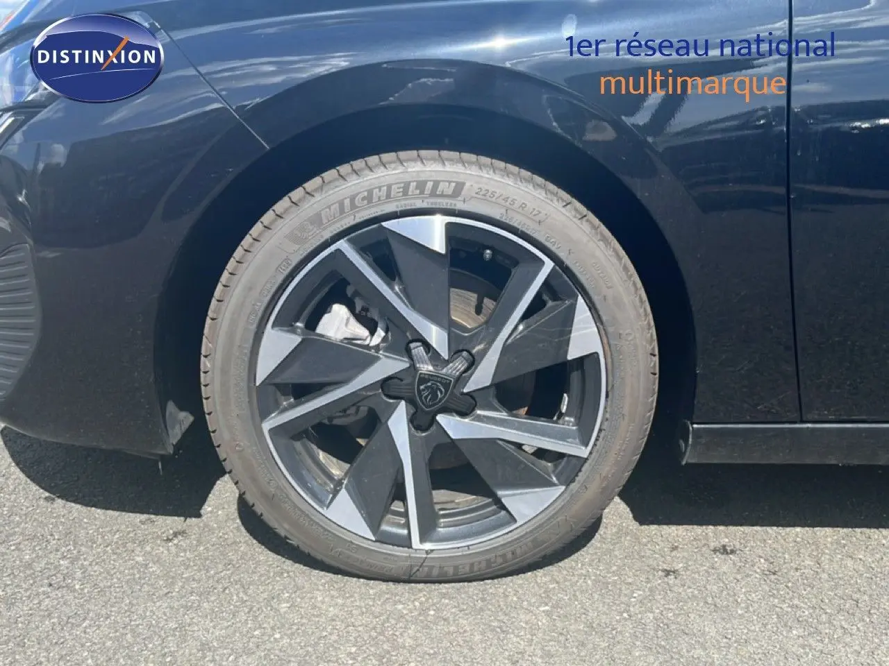 Gros plan sur la roue avant droite d’une Peugeot 308 noir métal avec jante alliage au design moderne.