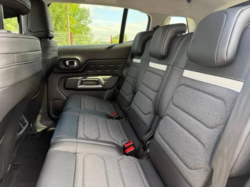 Vue intérieure côté gauche sur la 2e rangée de sièges coulissants noirs en tissu et cuir du Citroën C5 Aircross blanc.
