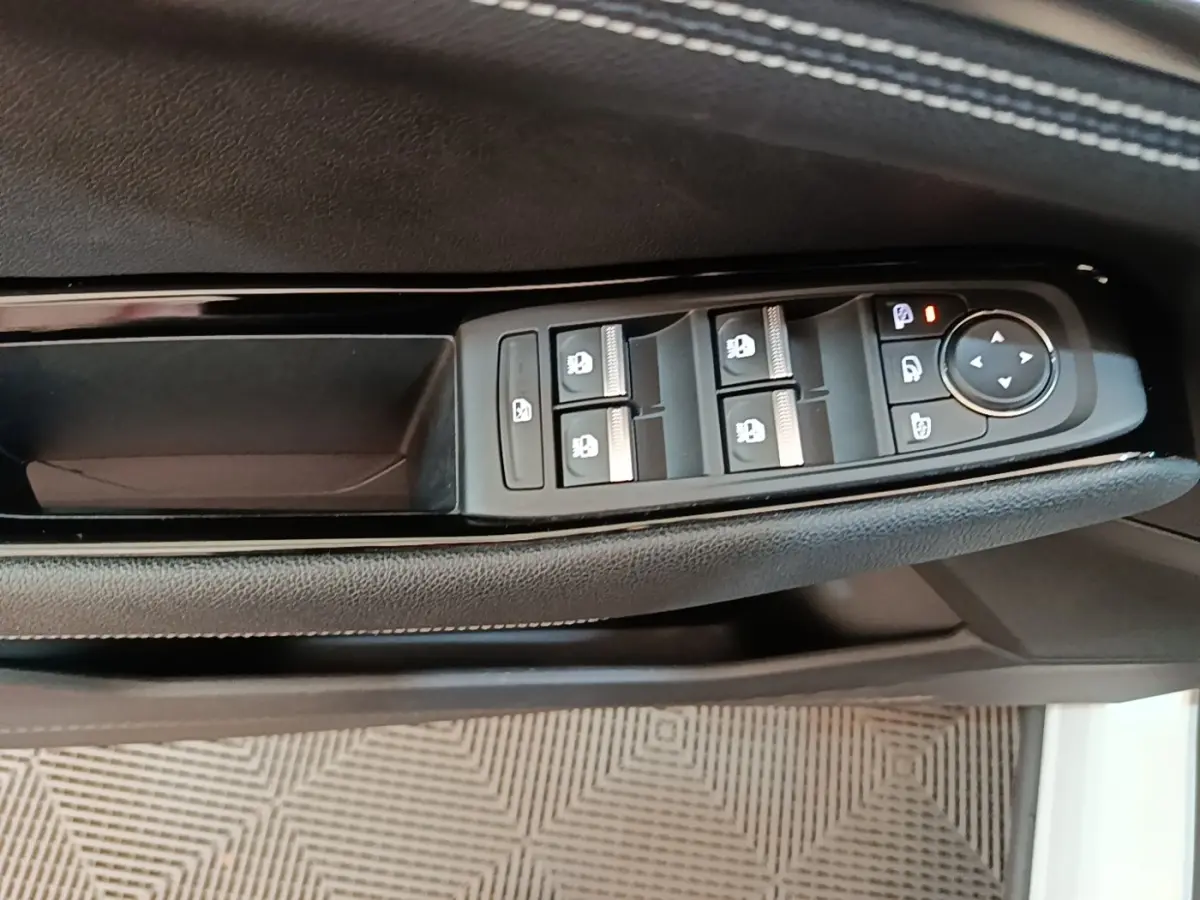 Détail des commandes de lève-vitres et rétroviseurs sur la porte côté conducteur du Renault Austral blanc 2023.