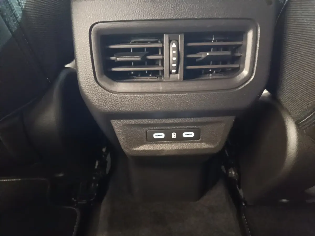 Détail des aérateurs arrière et ports USB-C noirs dans l’habitacle du Renault Austral blanc 2023.