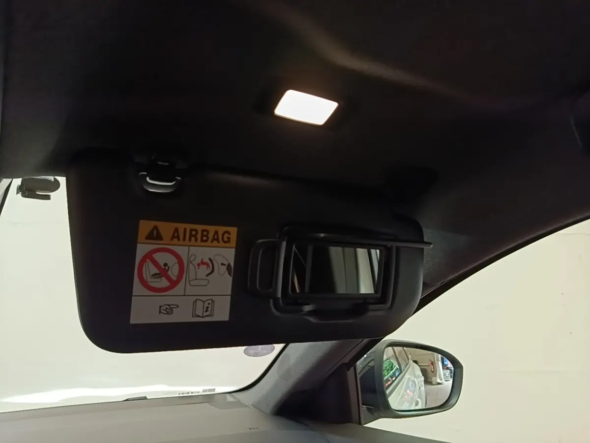 Vue intérieure du pare-soleil côté conducteur avec miroir et éclairage allumé sur Renault Austral blanc 2023.