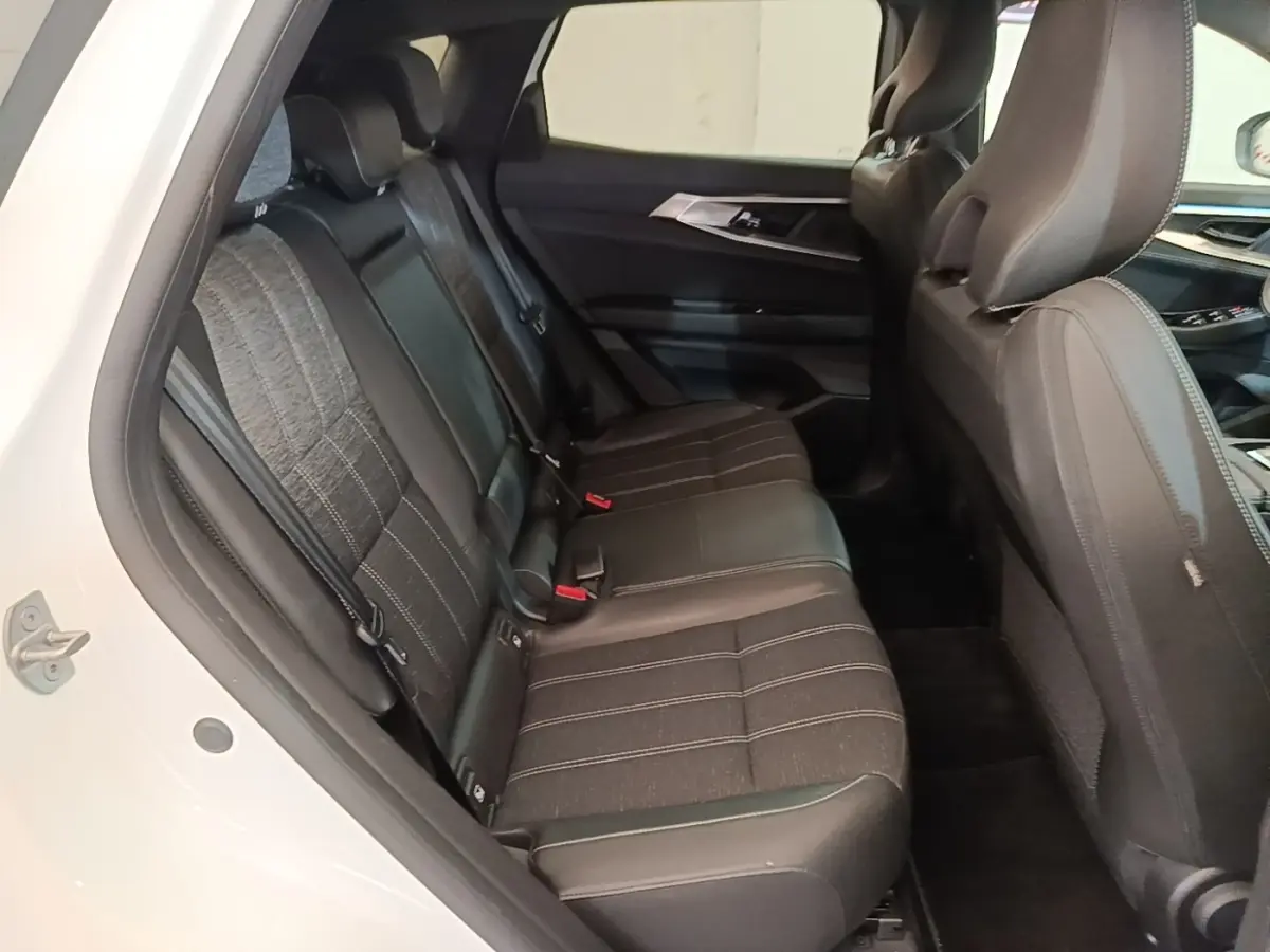 Vue intérieure côté gauche montrant la banquette arrière noire du Renault Austral blanc 2023, finition TECHNO E-TECH HYBRIDE.