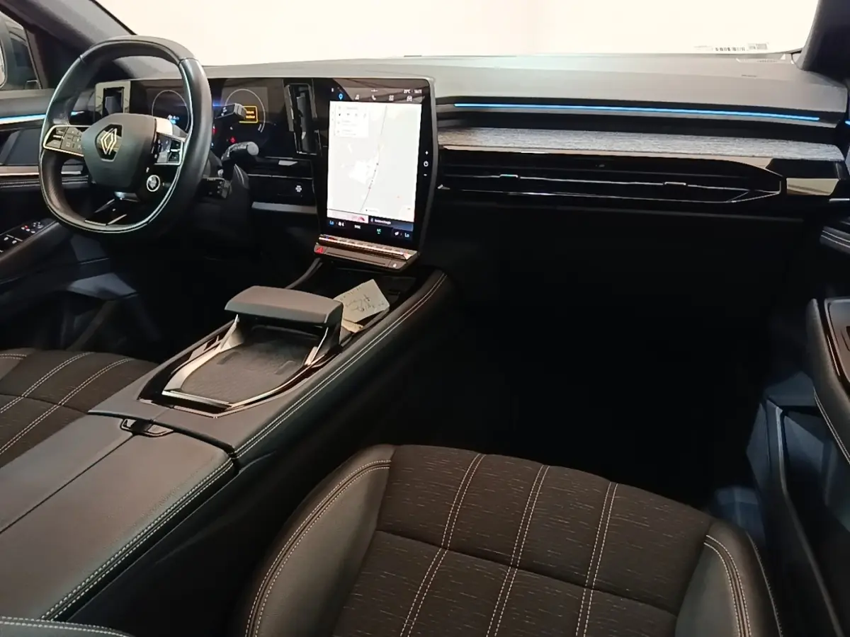Intérieur noir du Renault Austral 2023 vu côté passager, avec grand écran tactile central affichant la navigation.
