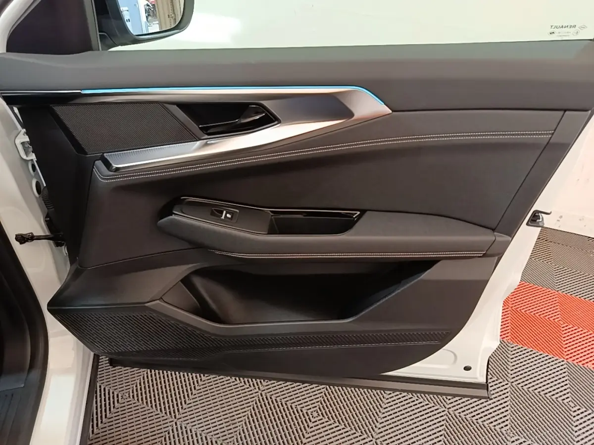 Vue intérieure côté gauche de la porte avant blanche du Renault Austral 2023 avec garniture noire et surpiqûres blanches.