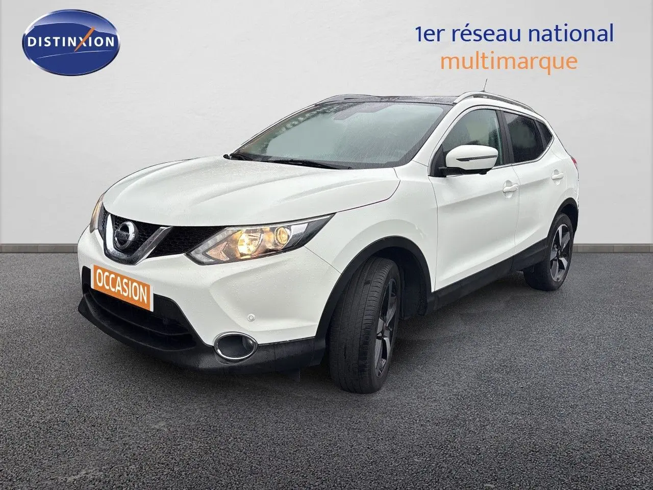 Nissan Qashqai blanc glacier en 3/4 avant droit avec phares allumés et jantes bi-ton noires.
