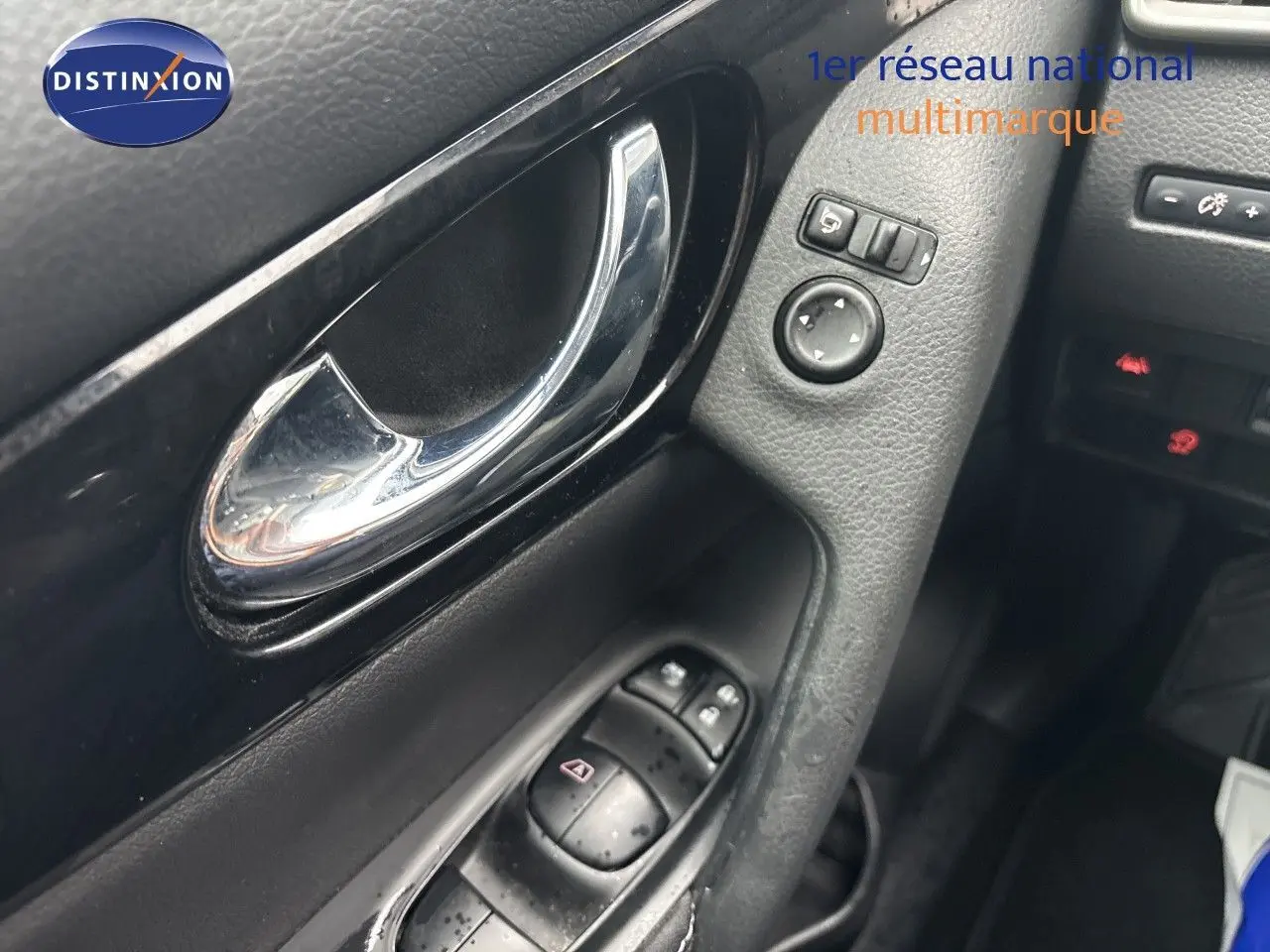 Gros plan sur la poignée intérieure et les commandes de porte côté conducteur du Nissan Qashqai blanc glacier 2017.