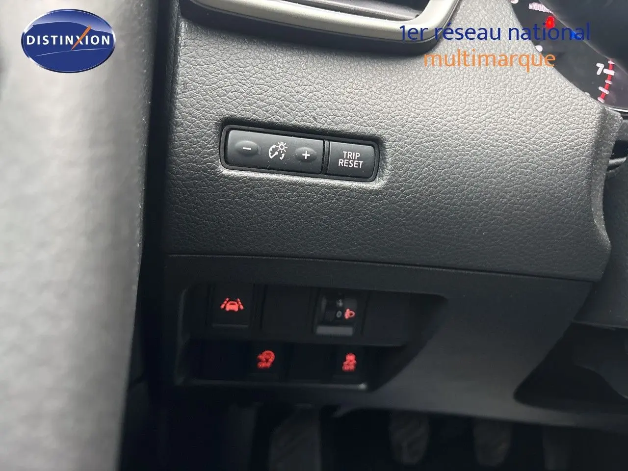 Gros plan sur les commandes de réglage du tableau de bord et des aides à la conduite du Nissan Qashqai blanc Glacier.