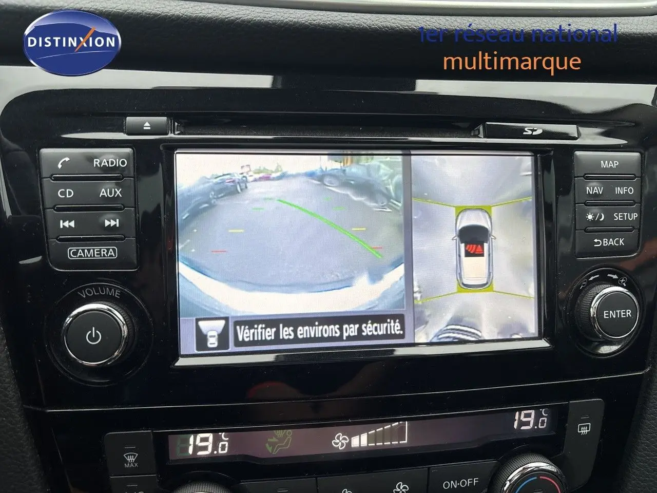 Écran central du Nissan Qashqai blanc montrant la caméra de recul et la vue à 360 degrés intérieure.