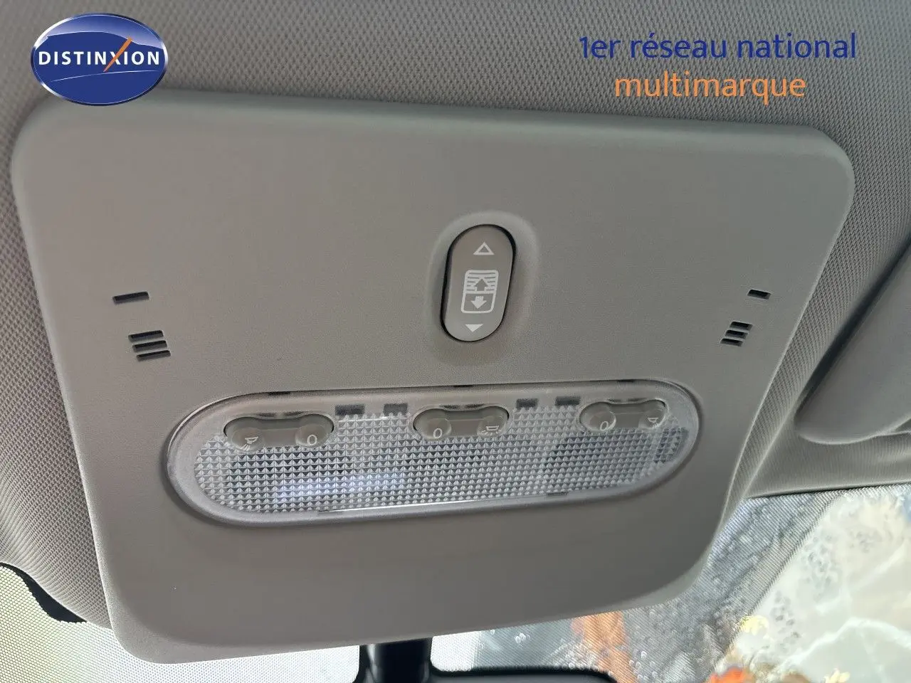 Plafonnier intérieur gris clair du Nissan Qashqai blanc glacier, vue en contre-plongée centrée sur les commandes d’éclairage.