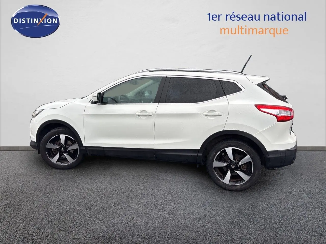 Profil gauche du Nissan Qashqai blanc glacier 2017 avec jantes bi-ton et vitres teintées.