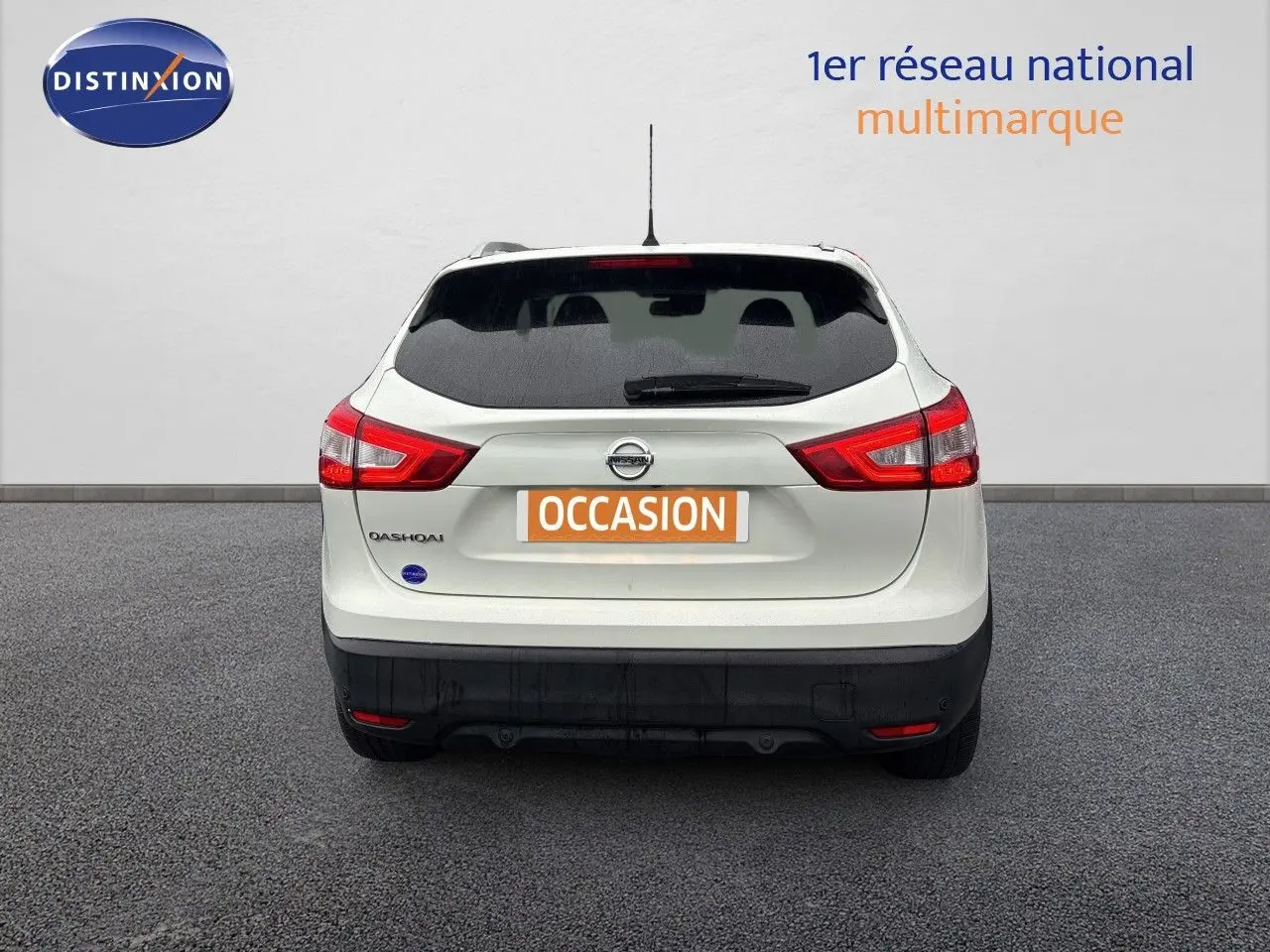 Vue arrière d'un Nissan Qashqai blanc glacier de 2017 avec feux rouges et plaque "OCCASION" visible.