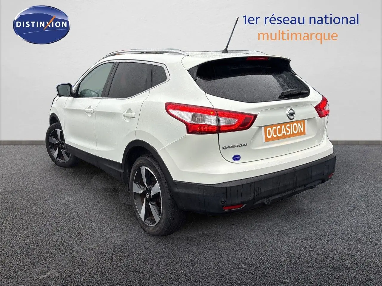 Vue 3/4 arrière droite d'un Nissan Qashqai blanc glacier avec jantes bi-ton et vitres teintées.