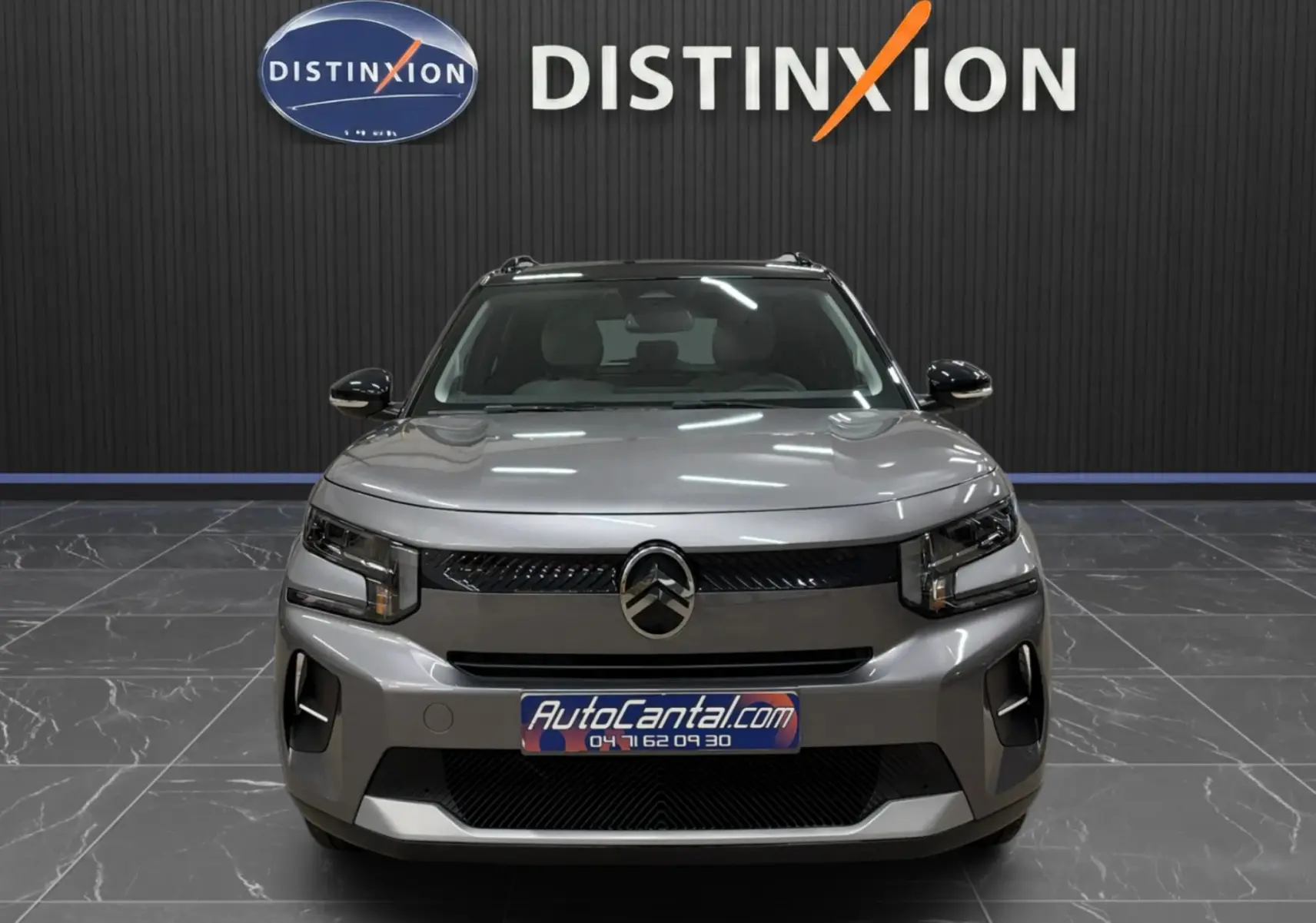Vue frontale d'une Citroën C3 électrique gris métallisé, avec calandre noire et éclairage LED moderne.
