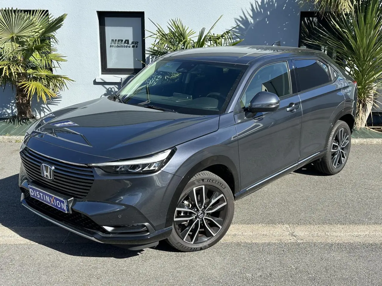 Honda HR-V gris métallisé vu en 3/4 avant droit avec jantes alliage 18 pouces et calandre noire lisse