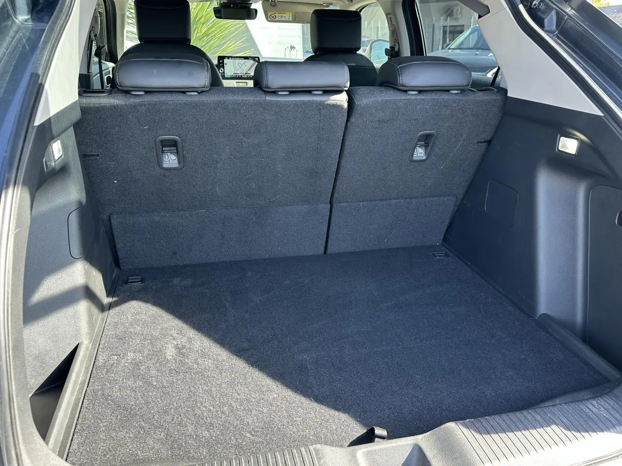 Coffre spacieux du Honda HR-V gris vu de l'arrière, avec sièges arrière en tissu noir et tablette tactile visible.