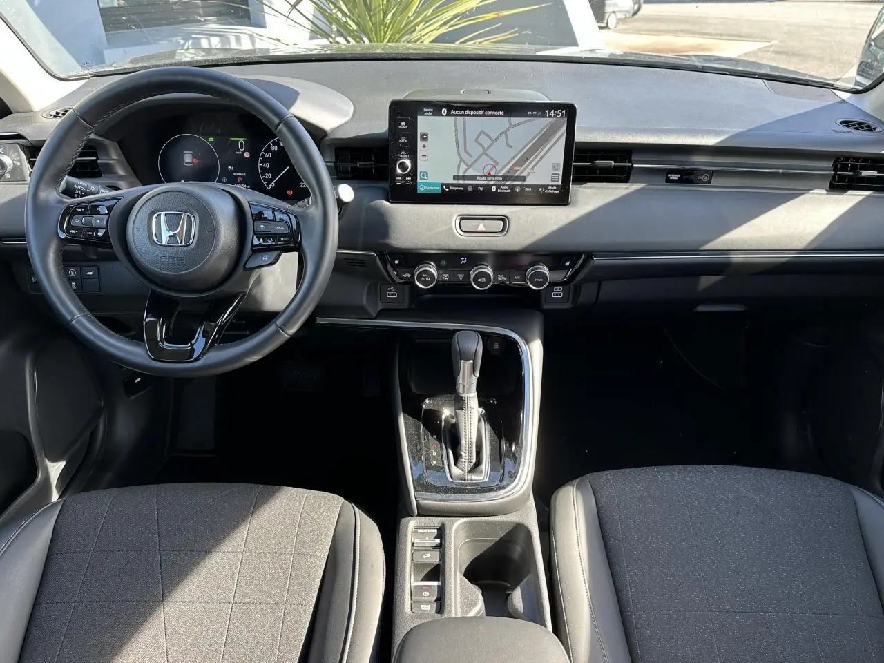 Intérieur du Honda HR-V 2025 en vue frontale, montrant le volant cuir, écran tactile et console centrale noire.