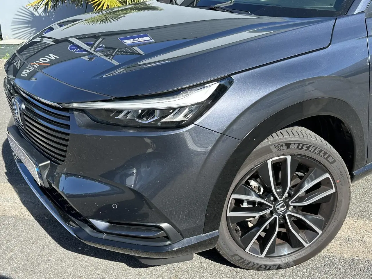 Vue 3/4 avant droit du Honda HR-V gris métallisé mettant en valeur son phare LED et jante alliage 18 pouces.