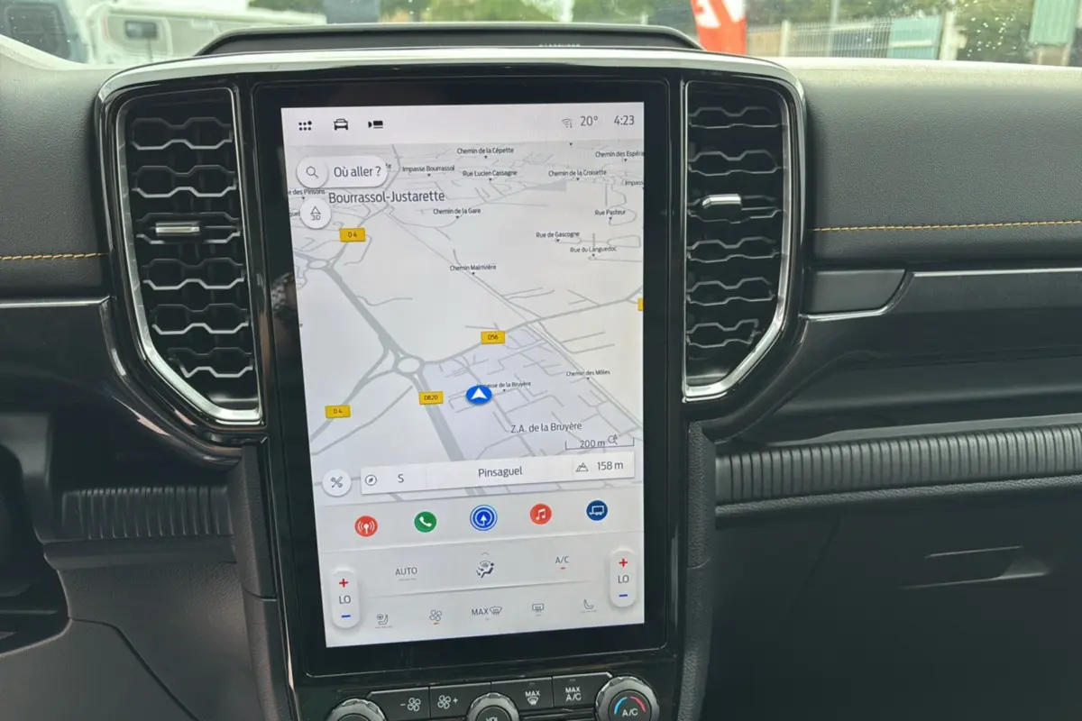 Vue rapprochée de l’écran tactile central du Ford Ranger 2025 noir agate, affichant la navigation GPS et commandes climatisation.