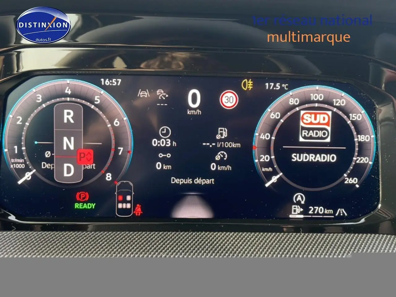 Vue rapprochée du tableau de bord numérique de la Volkswagen Golf gris, affichant la vitesse, régime et radio Sud Radio.