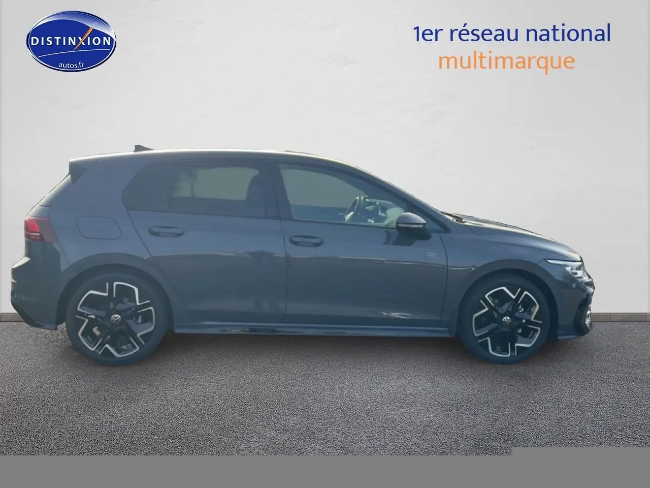 Vue latérale droite d'une Volkswagen Golf gris métallisé avec jantes alu noires et détails R-Line visibles.