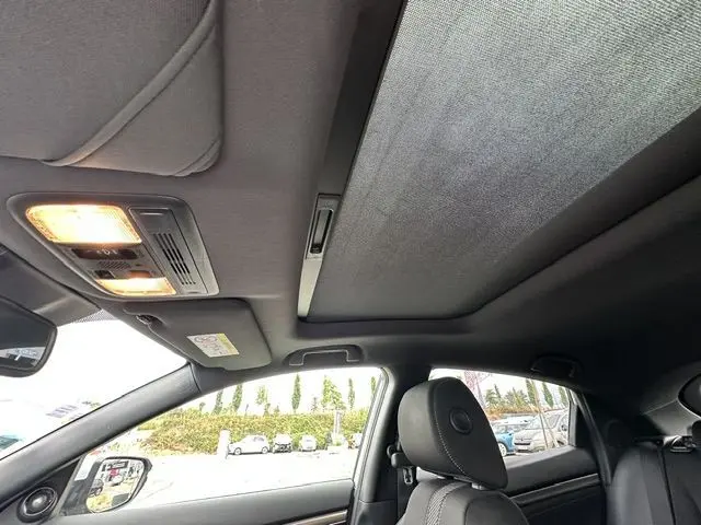 Vue intérieure de la Honda Civic grise, montrant le toit ouvrant panoramique et les sièges avant en tissu noir.