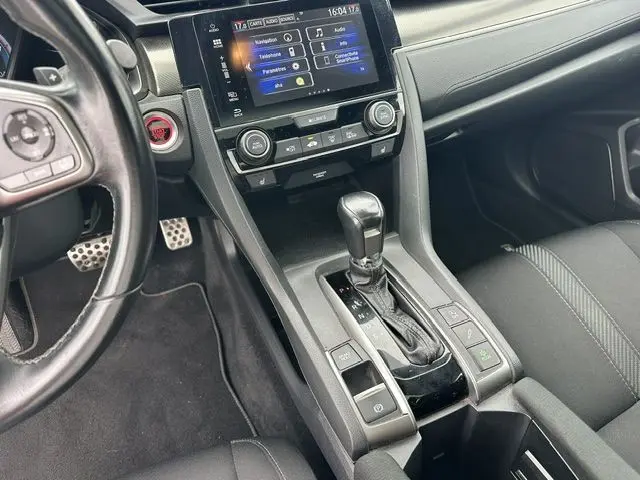 Vue intérieure centrée sur la console centrale et levier de vitesse d'une Honda Accord grise avec écran tactile et volant cuir noir.