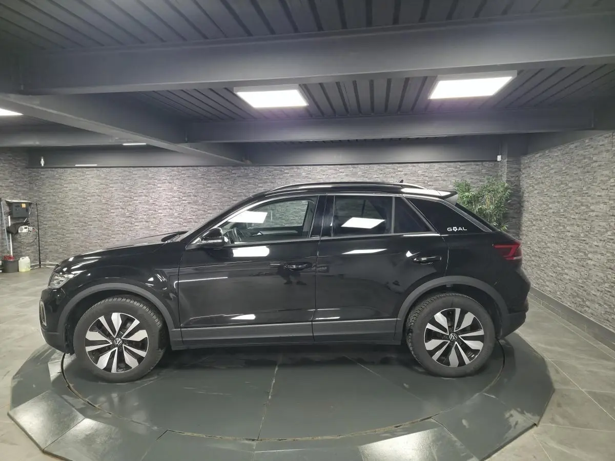 Volkswagen T-Roc noir en vue de profil côté gauche, avec jantes spécifiques et badge Goal à l'arrière.