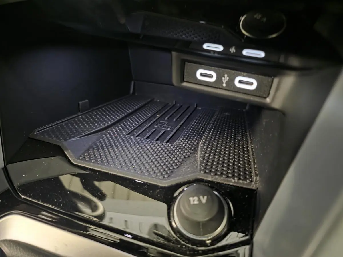 Gros plan sur la console centrale noire du Volkswagen T-Roc 2025 avec ports USB-C et prise 12V visible.