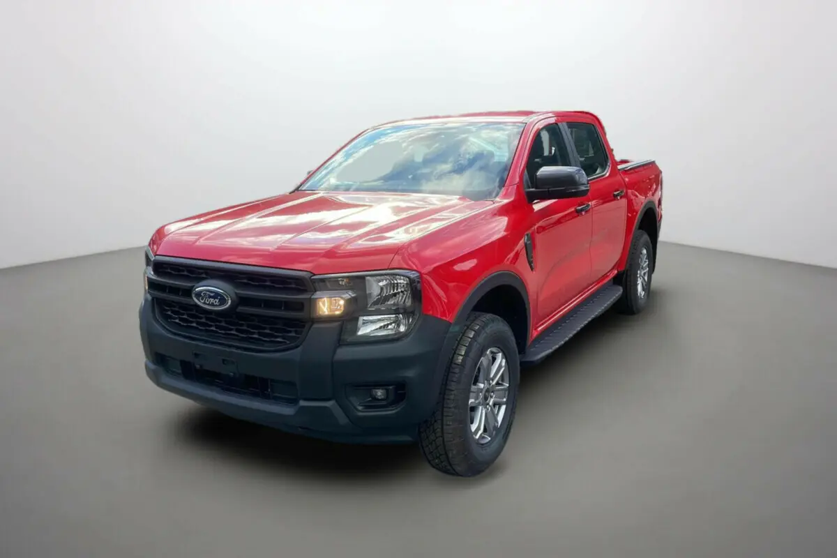 Ford Ranger 2025 rouge racing en vue 3/4 avant droit avec calandre noire et phares allumés.