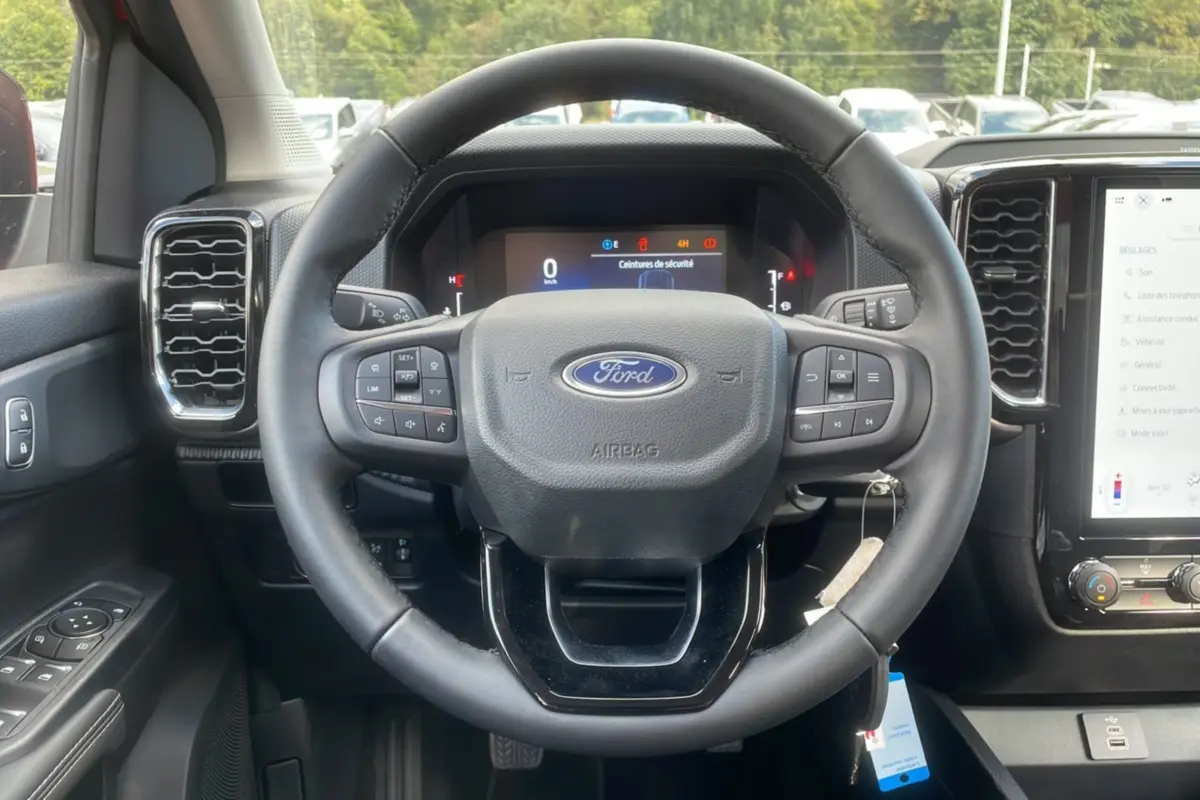 Intérieur du Ford Ranger 2025, vue centrée sur le volant multifonction et le tableau de bord numérique.