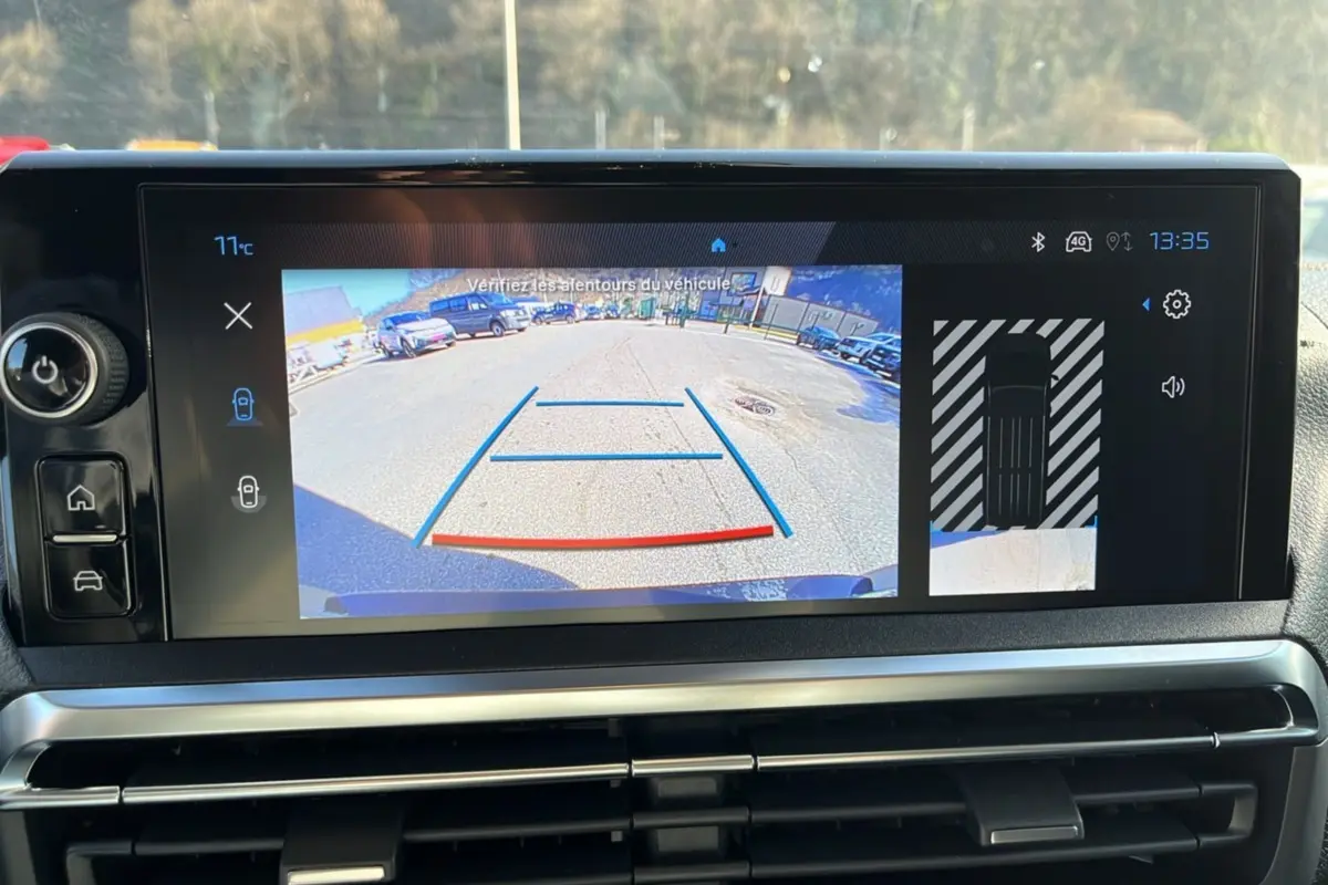 Écran central du Peugeot Traveller 2025 montrant la caméra de recul avec vue arrière et top-down du véhicule.