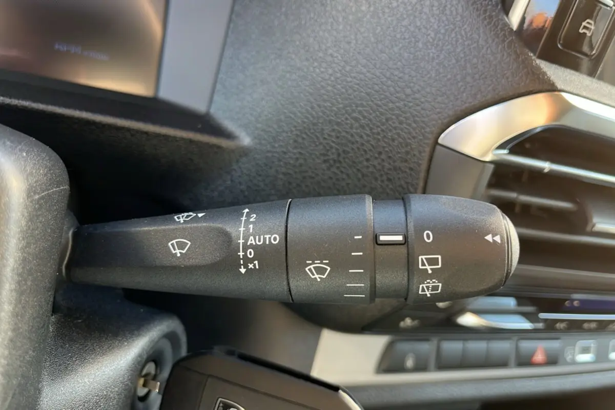 Gros plan sur la commande des essuie-glaces du Peugeot Traveller 2025, avec tableau de bord et aérateur visibles.