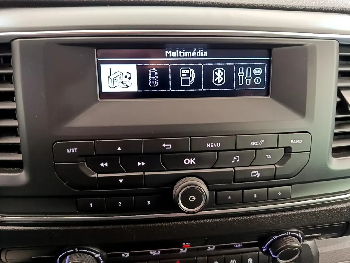 Vue rapprochée du tableau de bord du Peugeot Traveller 2018 blanc, mettant en valeur l’écran multimédia et les commandes audio.