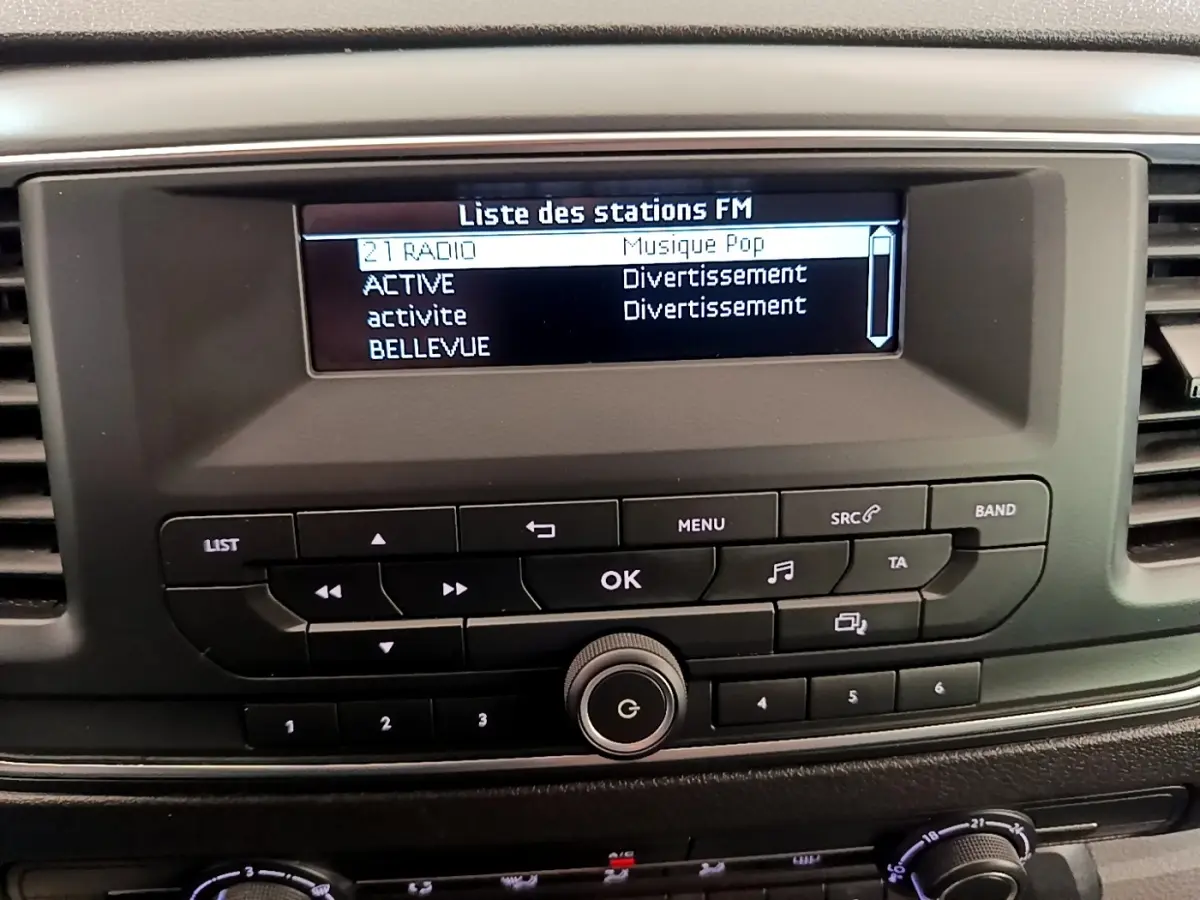 Tableau de bord du Peugeot Traveller 2018 avec écran radio FM et commandes noires en vue frontale rapprochée.