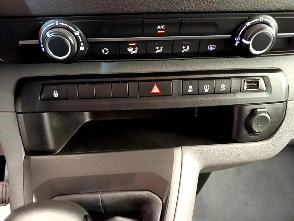 Détail du tableau de bord du Peugeot Traveller 2018, montrant les commandes de climatisation et la console centrale avec prise 12V.