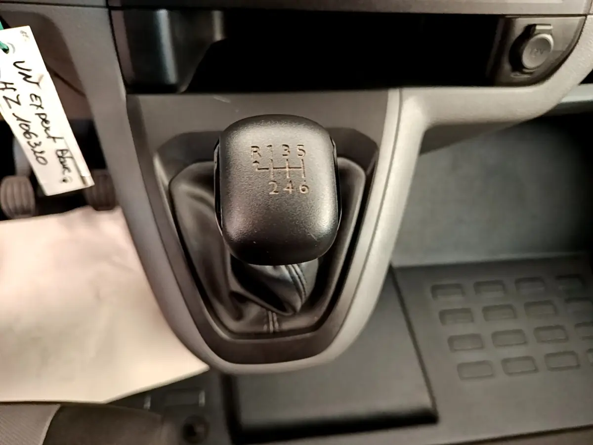 Gros plan sur le levier de vitesses manuel noir du Peugeot Traveller blanc de 2018, montrant les six rapports et la marche arrière.