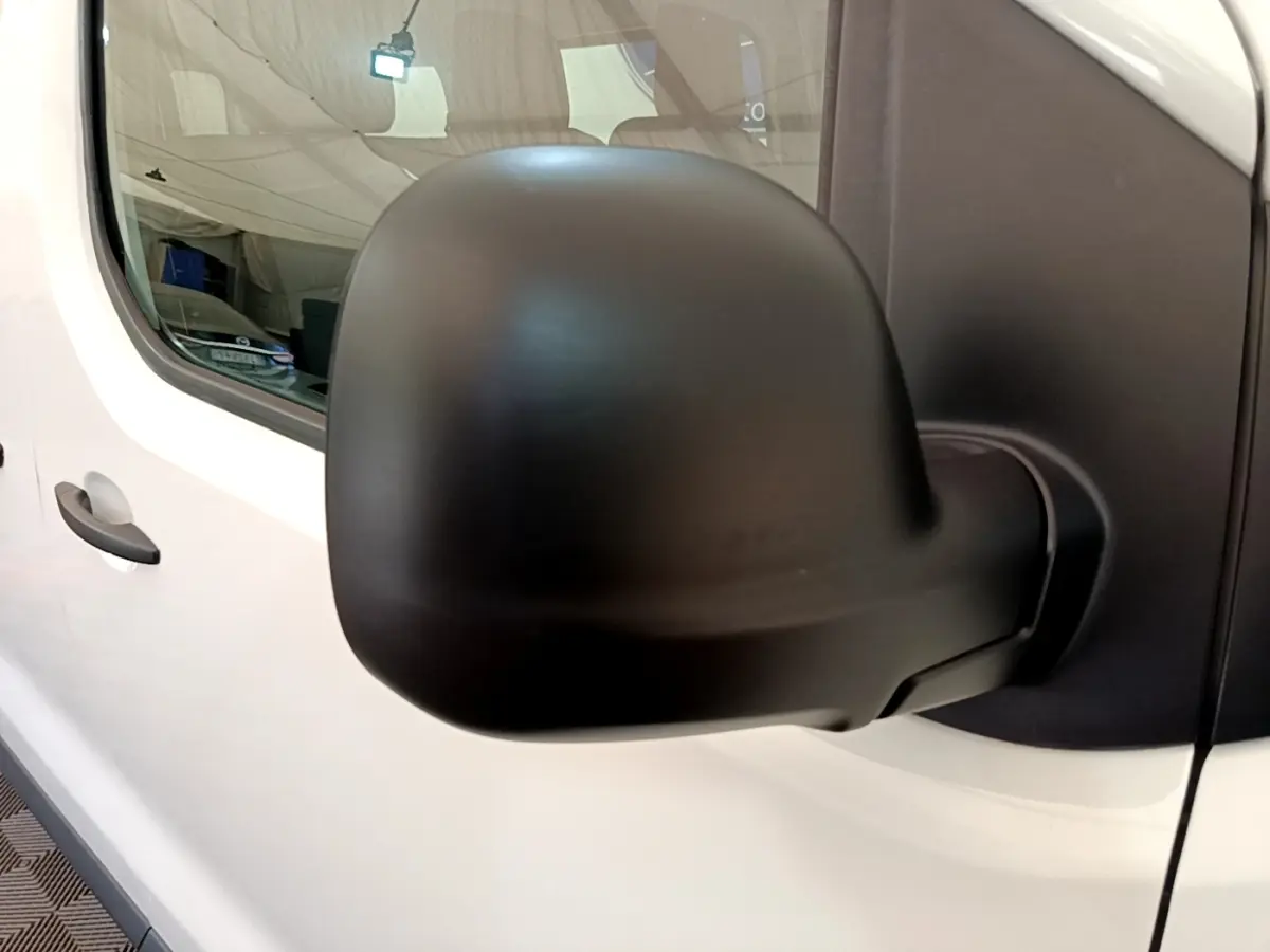 Rétroviseur noir en gros plan côté gauche du Peugeot Traveller blanc diesel de 2018, vue sur la porte avant.